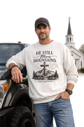He Still Moves Mountains Crewneck Sweatshirt — Christian Cross Mountain Graphic
